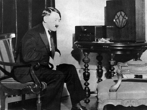 Adolf Hitler is listening to the radio.